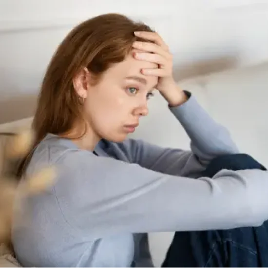 anxious-woman-sitting-couch-side-view